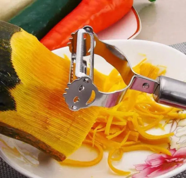 Yam being peeled with a vegetable peeler on a floral plate