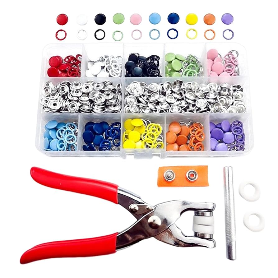 Assorted buttons, rings, and a button hole puncher on a white background