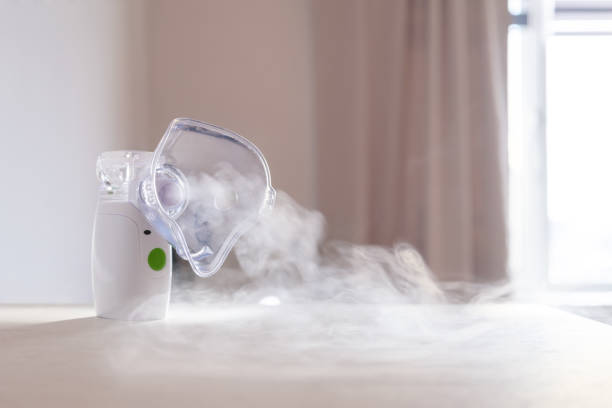 Nebulizer emitting mist in a room with curtains and a window.