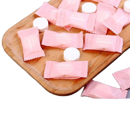 Pink packets and white capsules on a wooden board